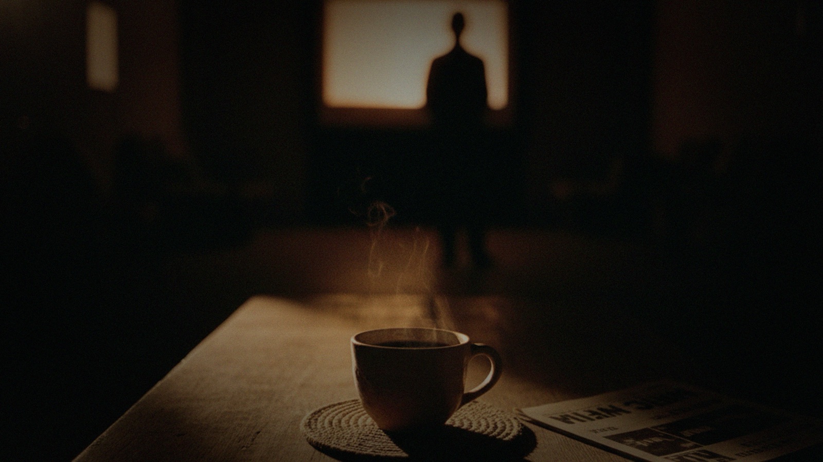 A ceramic cup on a wooden surface, steam rising, in a dim lamplit room with a silhouette visible through a backlit window